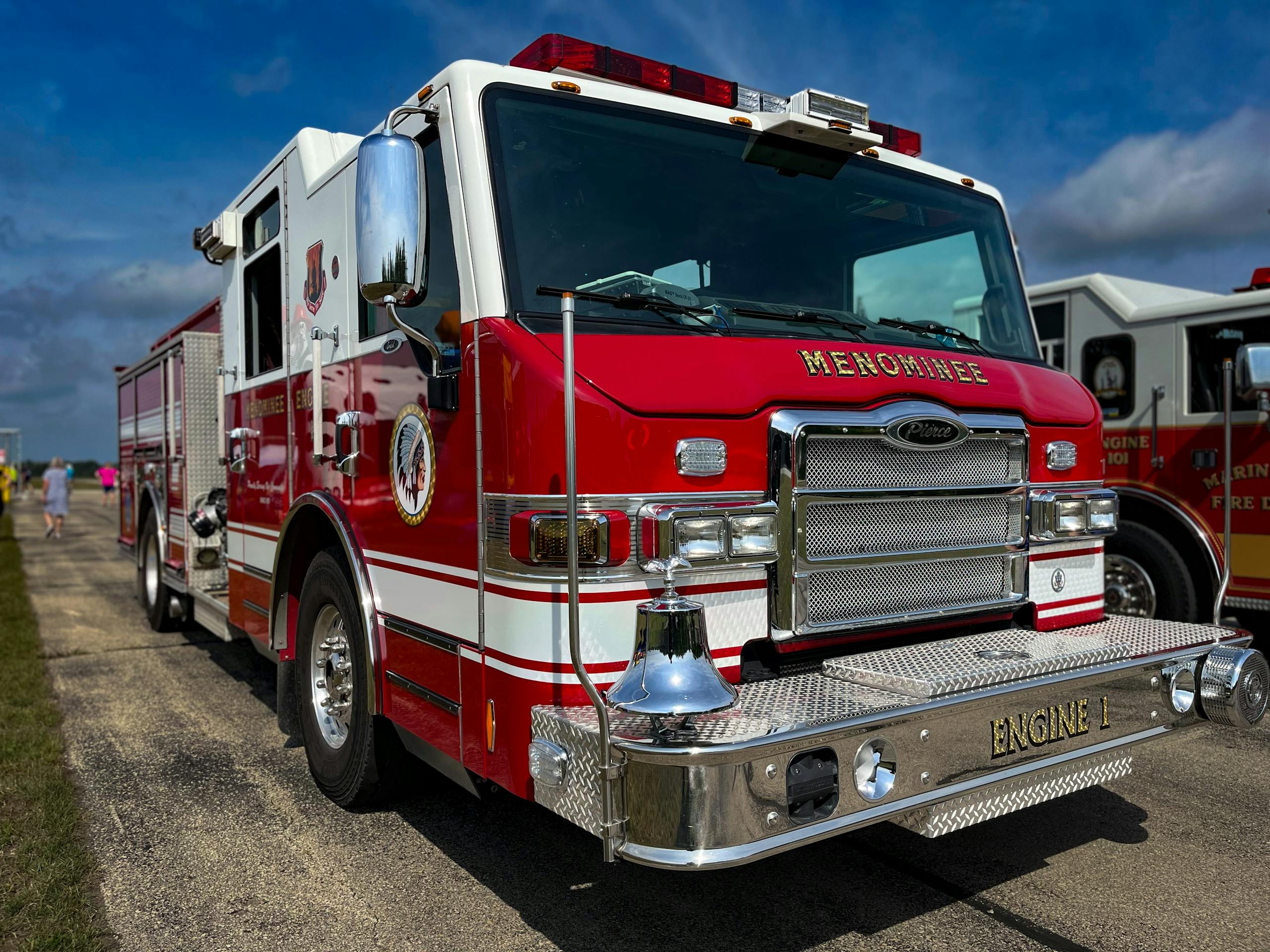 Vibrant red firetruck marked 'ENGINE 1' parked outdoors in daylight, showcasing emergency vehicle details.